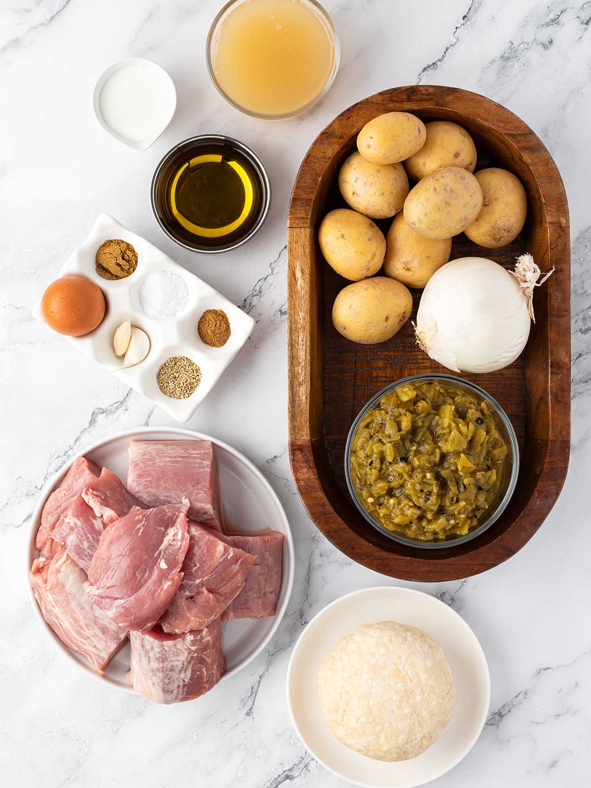 The ingredients for this recipe placed in plates displayed on a white counter.